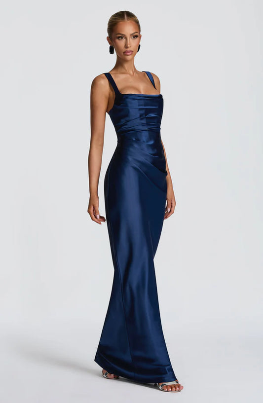 Side profile of the Revalline Calanthe Maxi Dress highlighting the flowing satin fabric, asymmetric pleats, and elegant full-length silhouette.