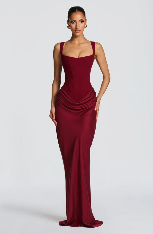 Woman wearing a burgundy evening gown on a white background