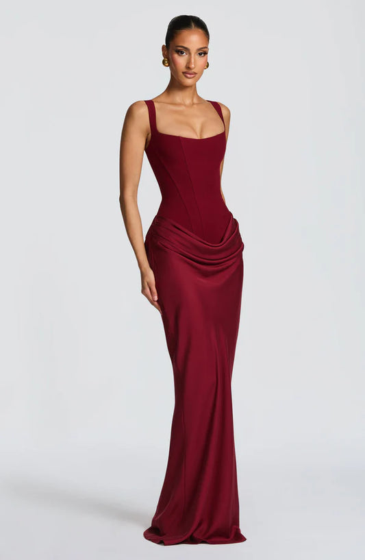 Burgundy evening gown on a model against a white background