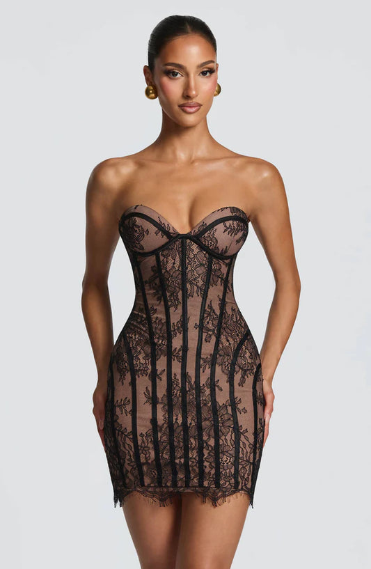 Woman wearing a black lace dress against a white background